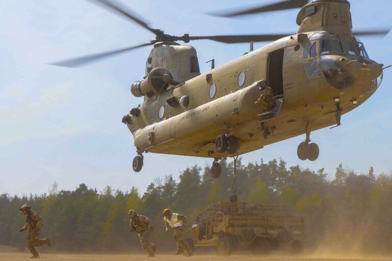 US Army soldiers exiting chinook helicopter and running