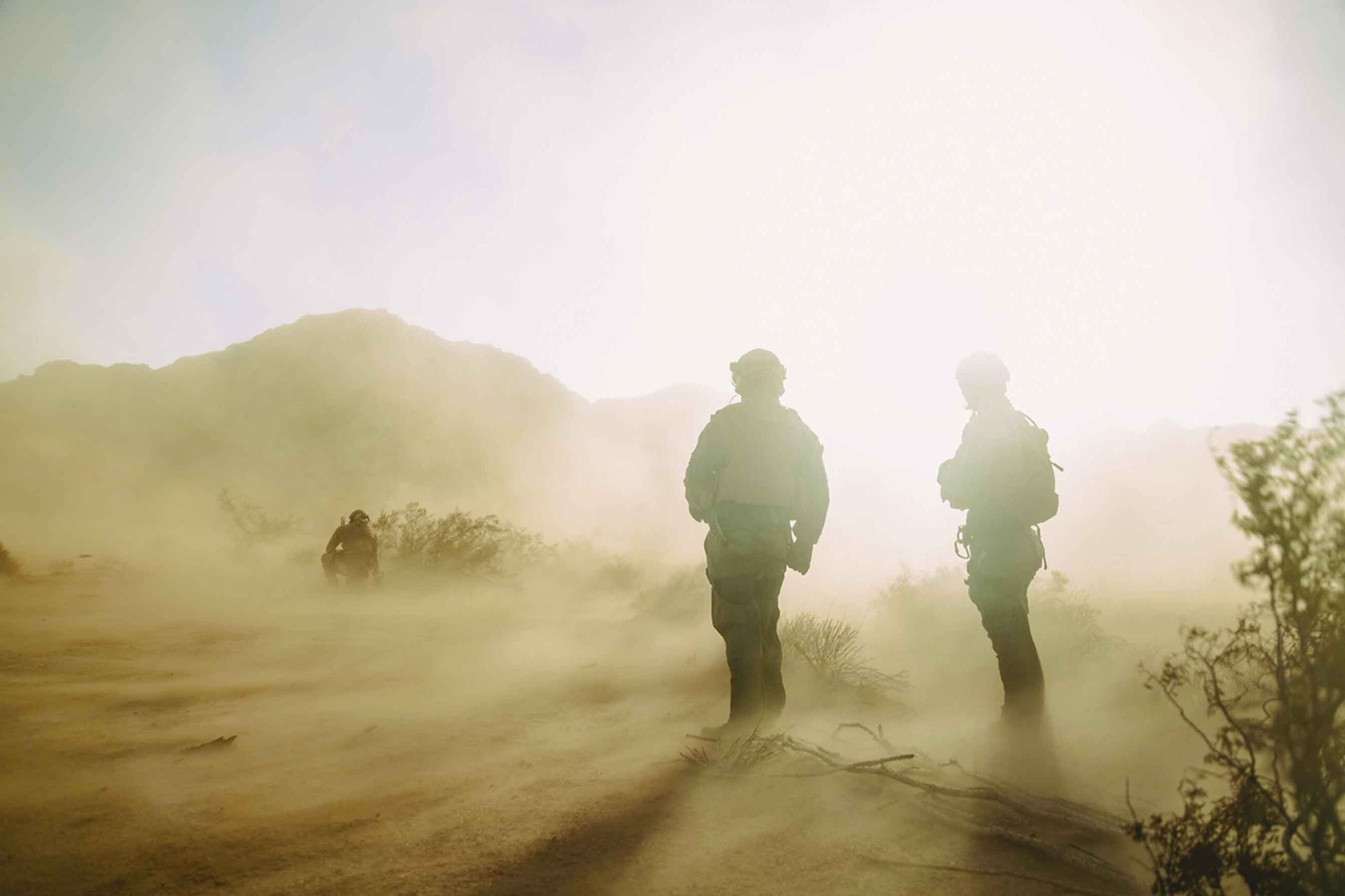 two US soldiers standing against wind sand